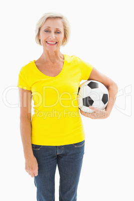 Mature blonde holding football smiling at camera