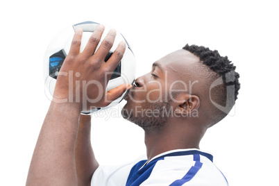 Football player in blue kissing ball