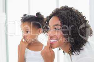 Pretty mother putting face cream on with her daughter