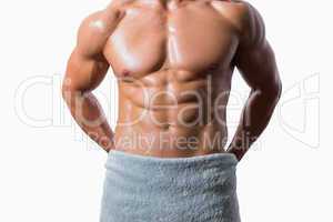 Mid section of a shirtless muscular man wrapped in white towel
