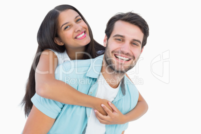 Happy casual man giving pretty girlfriend piggy back