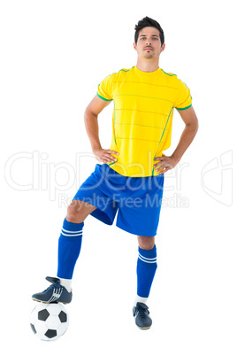 Football player in yellow standing with the ball