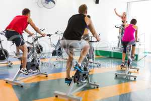 Spin class working out with motivational instructor