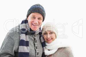 Mature couple in winter clothes smiling at camera