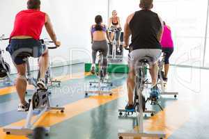 Spin class working out with motivational instructor