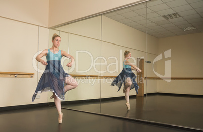 Beautiful ballerina dancing in front of mirror