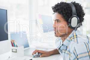 Young designer listening to music as he works