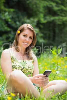 Relaxed woman text messaging in field