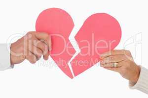 Couple holding a broken paper heart