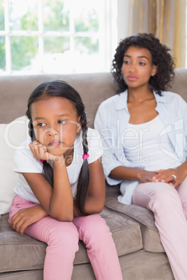 Pretty mother sitting on couch after an argument with daughter