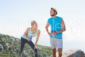 Fit couple standing holding water bottles
