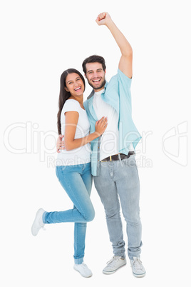 Happy casual couple cheering at camera