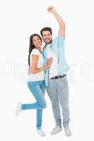 Happy casual couple cheering at camera