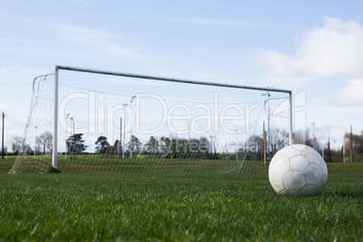 Football on an empty pitch in front of goal