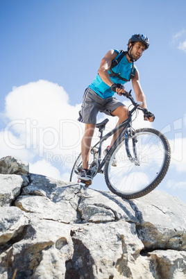 Fit man cycling on rocky terrain