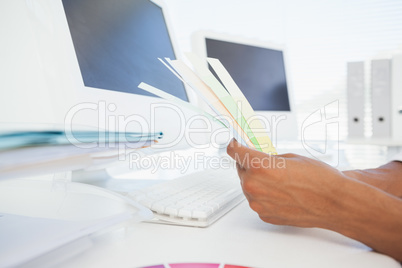 Designer working at desk holding colour samples