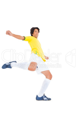 Football player in yellow kicking