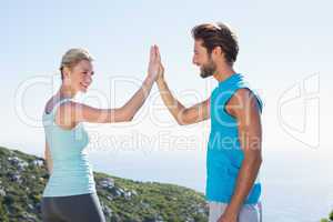 Fit couple standing high fiving