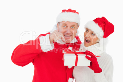 Festive couple smiling and holding gift