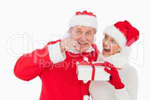 Festive couple smiling and holding gift
