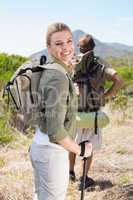 Attractive hiking couple walking on mountain trail woman smiling