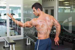 Shirtless bodybuilder posing in gym