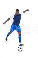 Football player in blue kicking ball