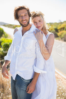 Attractive couple smiling at camera road side