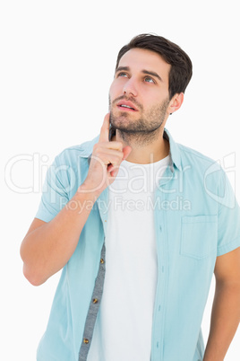 Happy casual man thinking with hand on chin
