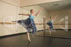 Beautiful ballerina dancing in front of mirror