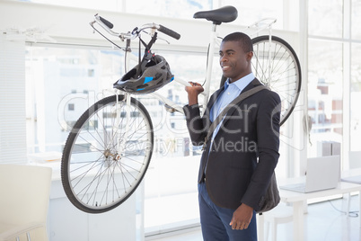 Happy businessman carrying his bicycle