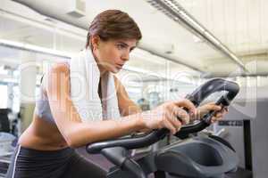 Fit focused brunette working out on the exercise bike