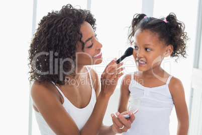 Pretty mother teaching her daughter about makeup