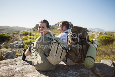 Hiking couple sitting on mountain terrain Hiking couple sitting on mountain terrain