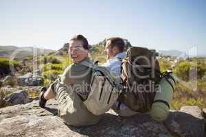 Hiking couple sitting on mountain terrain