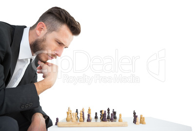 Hipster businessman playing game of chess