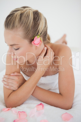 Pretty blonde lying on massage table with rose petals