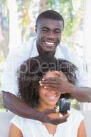 Man covering the eyes of his girlfriend while preparing proposal