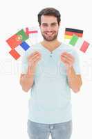 Handsome man holding various european flags
