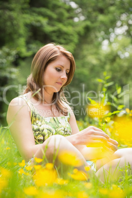 Thoughtful woman relaxing in field