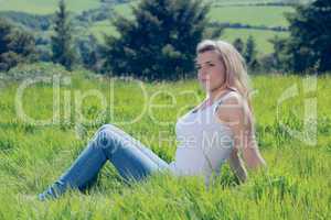 Pretty blonde thinking while sitting on grass