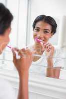 Pretty woman brushing her teeth