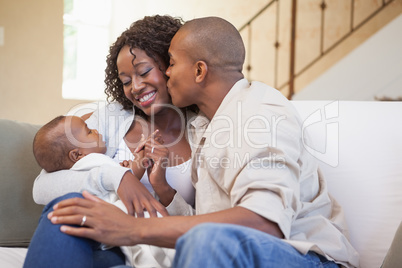 Happy parents spending time with baby on the couch