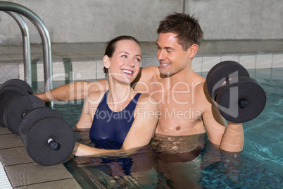 Happy couple working out with foam dumbbells