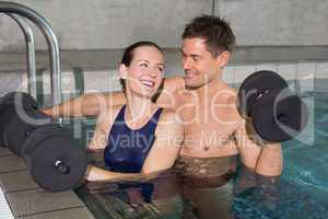 Happy couple working out with foam dumbbells