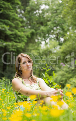 Cute young woman relaxing in field