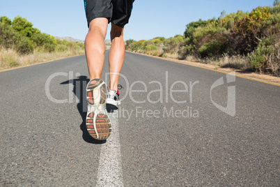 Fit man jogging on the open road