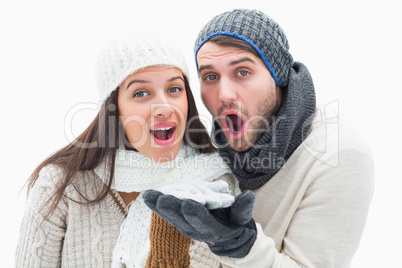 Attractive young couple in warm clothes blowing