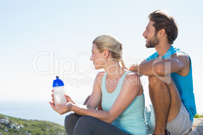 Fit couple taking a break at summit looking at the view