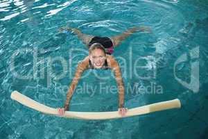 Fit blonde swimming with foam roller